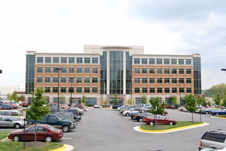 Exterior view of Monument Homecare building with a parking lot and glass central atrium.
