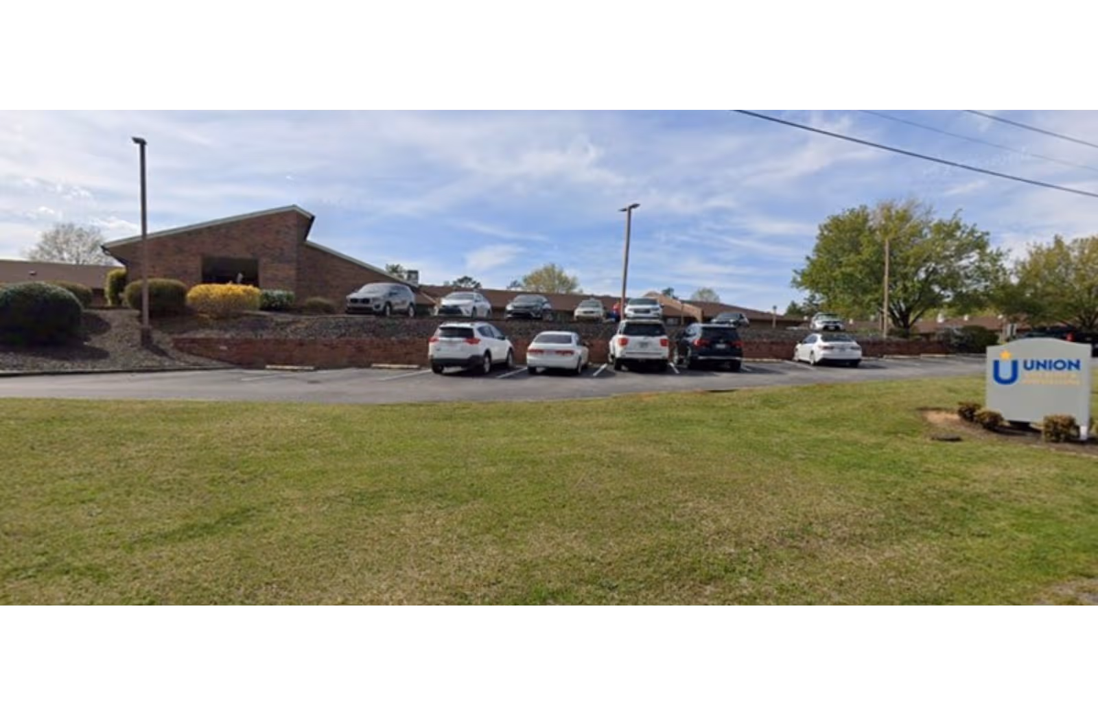 Exterior view of Union Post Acute facility with a brick building and parked cars.