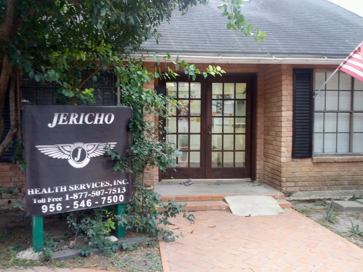 Brick building entrance with double doors and a Jericho Health Services sign.