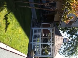 Front exterior of Madison Tower with a white porch and green lawn.