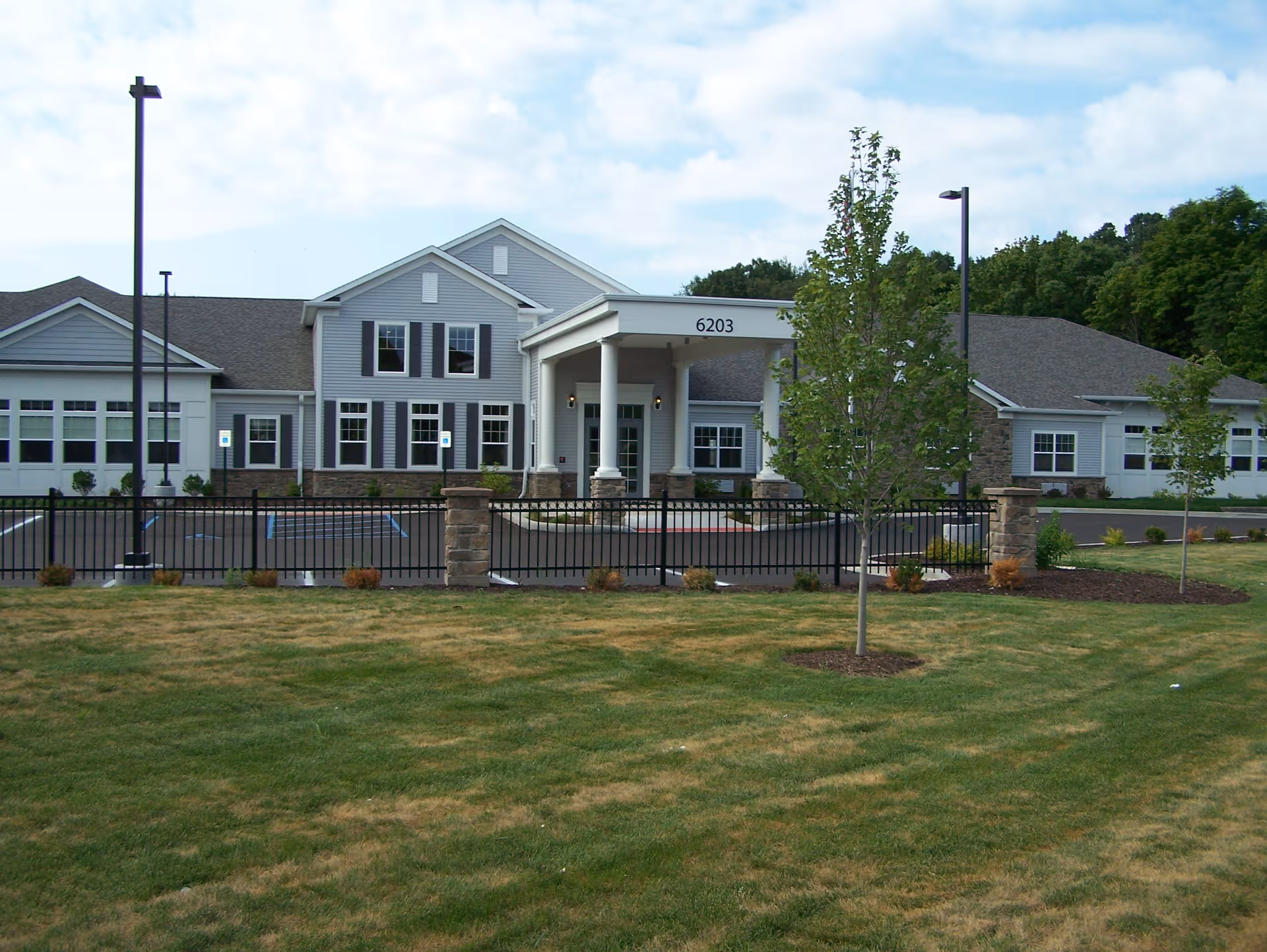 Front exterior of North Woods Village of Kalamazoo with entry and lawn.