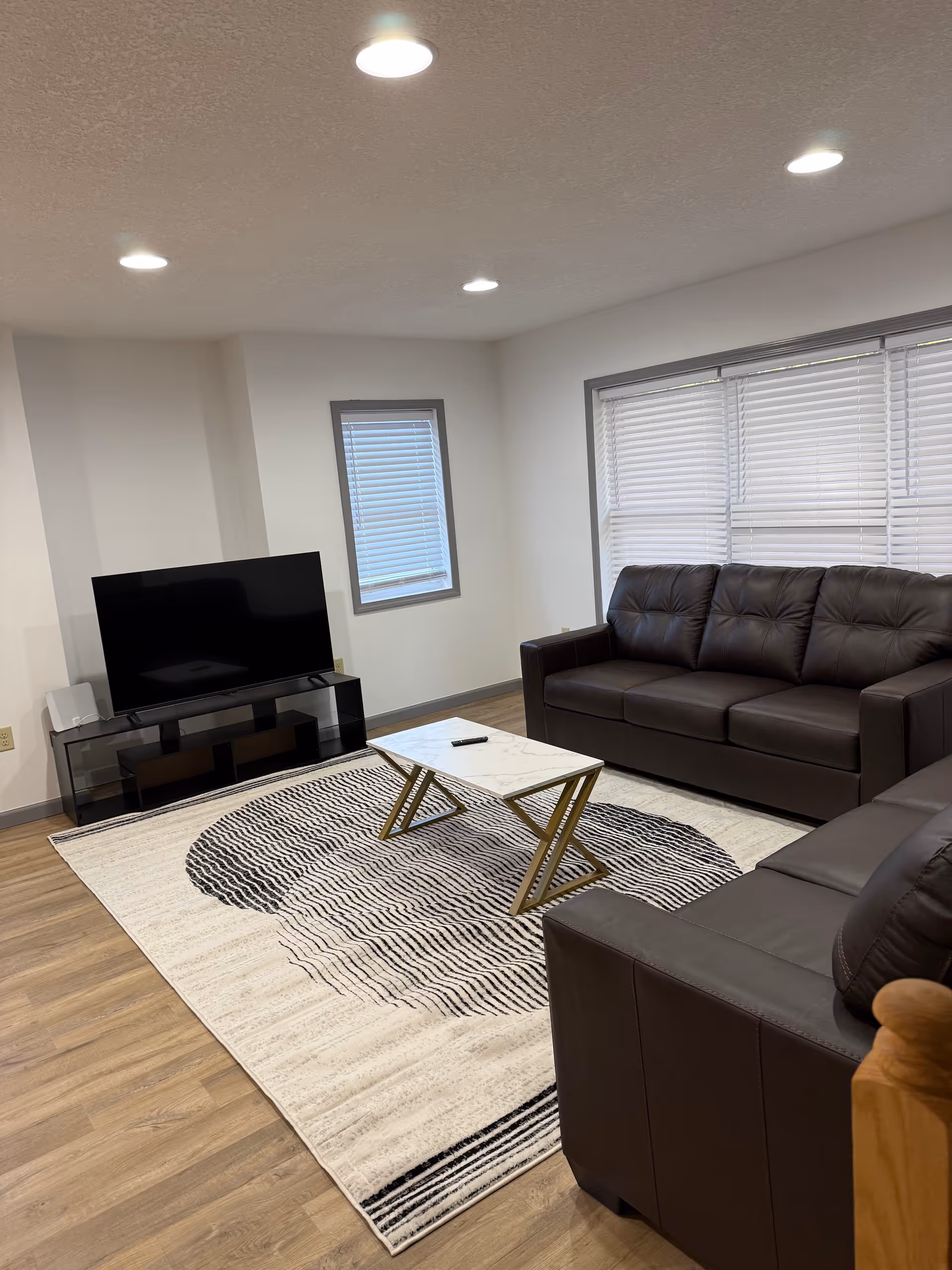 Bright living room in Blue Sky Assisted Living with leather sofa, coffee table, and TV.