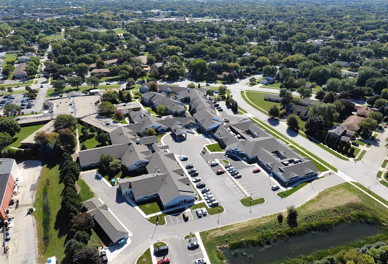 Aerial view of a senior living campus with connected buildings and parking areas.