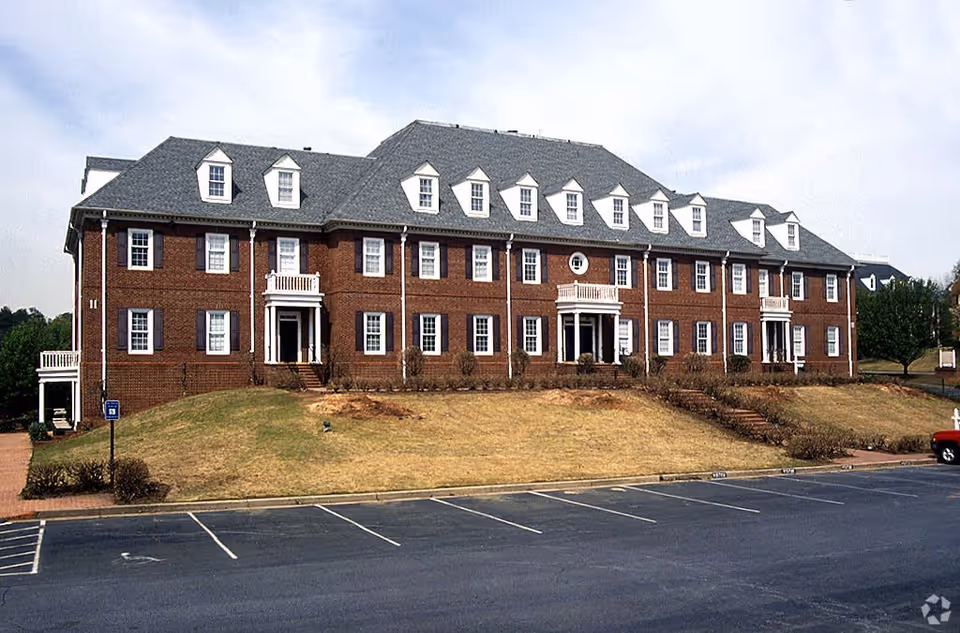 Exterior of Helping Homes Homecare facility: brick building with dormer windows and a front entrance.