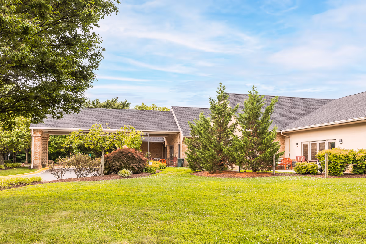 Exterior view of Oak Manor Center for Rehabilitation and Healthcare with lawn and trees.