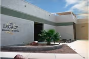 Exterior view of The Legacy Rehab & Care Center with a small palm near the entrance.