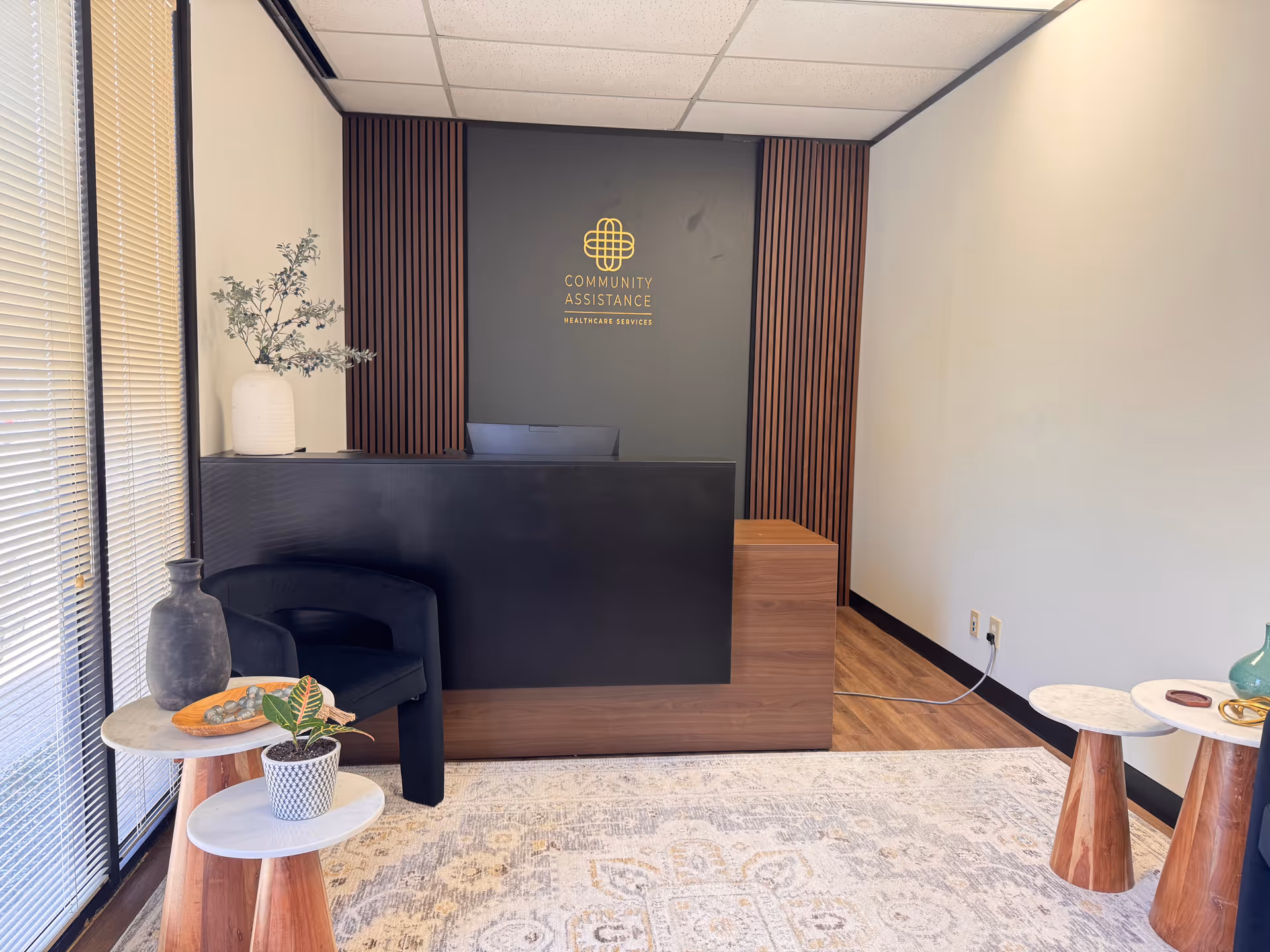 Reception area for Community Assistance Healthcare Services with dark wood desk and seating.