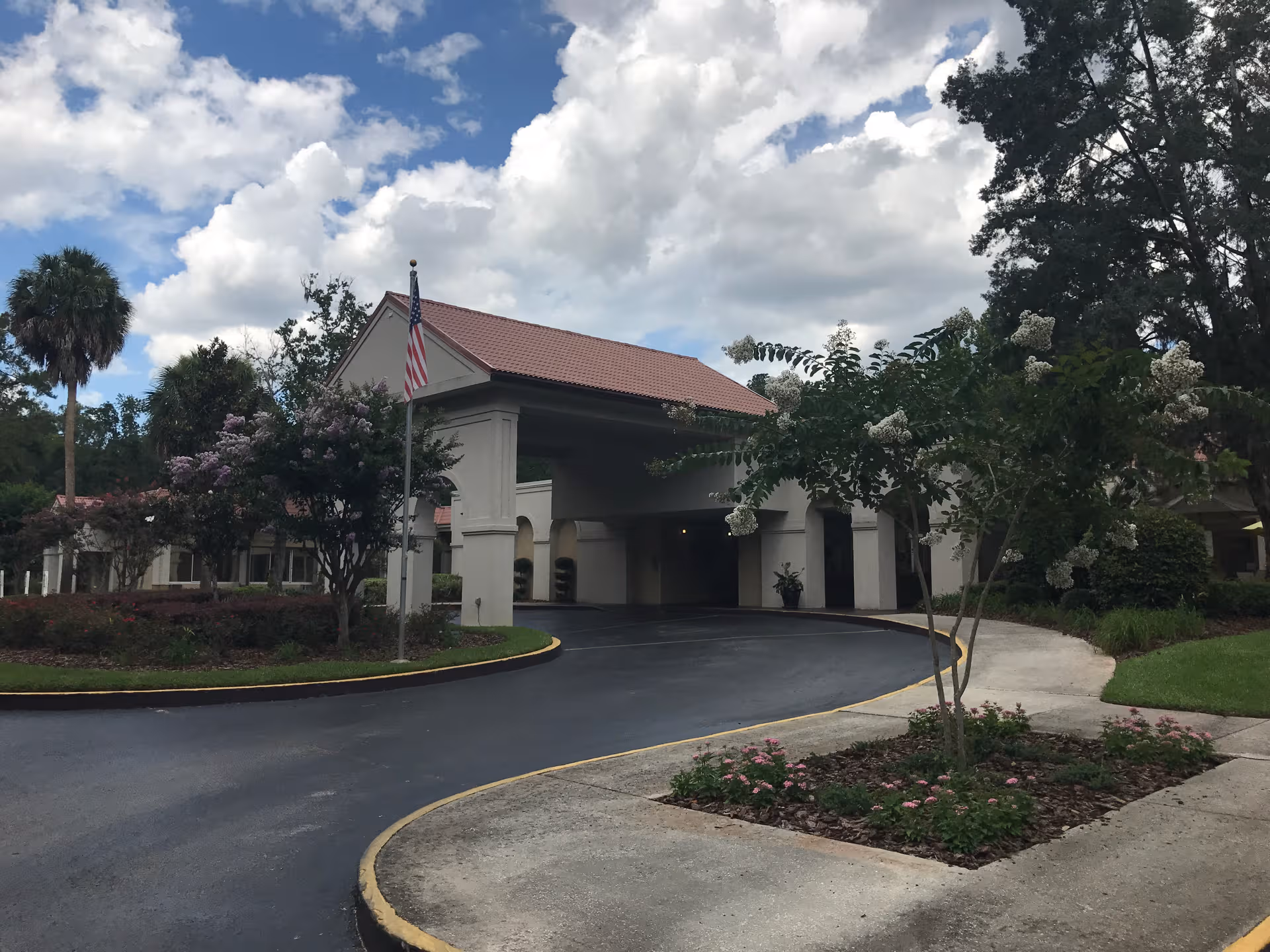Wide view of the facility entrance with curved driveway and landscaping.