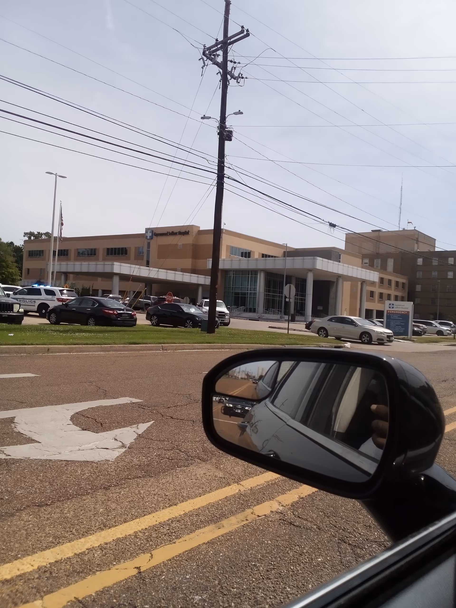Exterior view of Greenwood Leflore Hospital with cars in foreground.