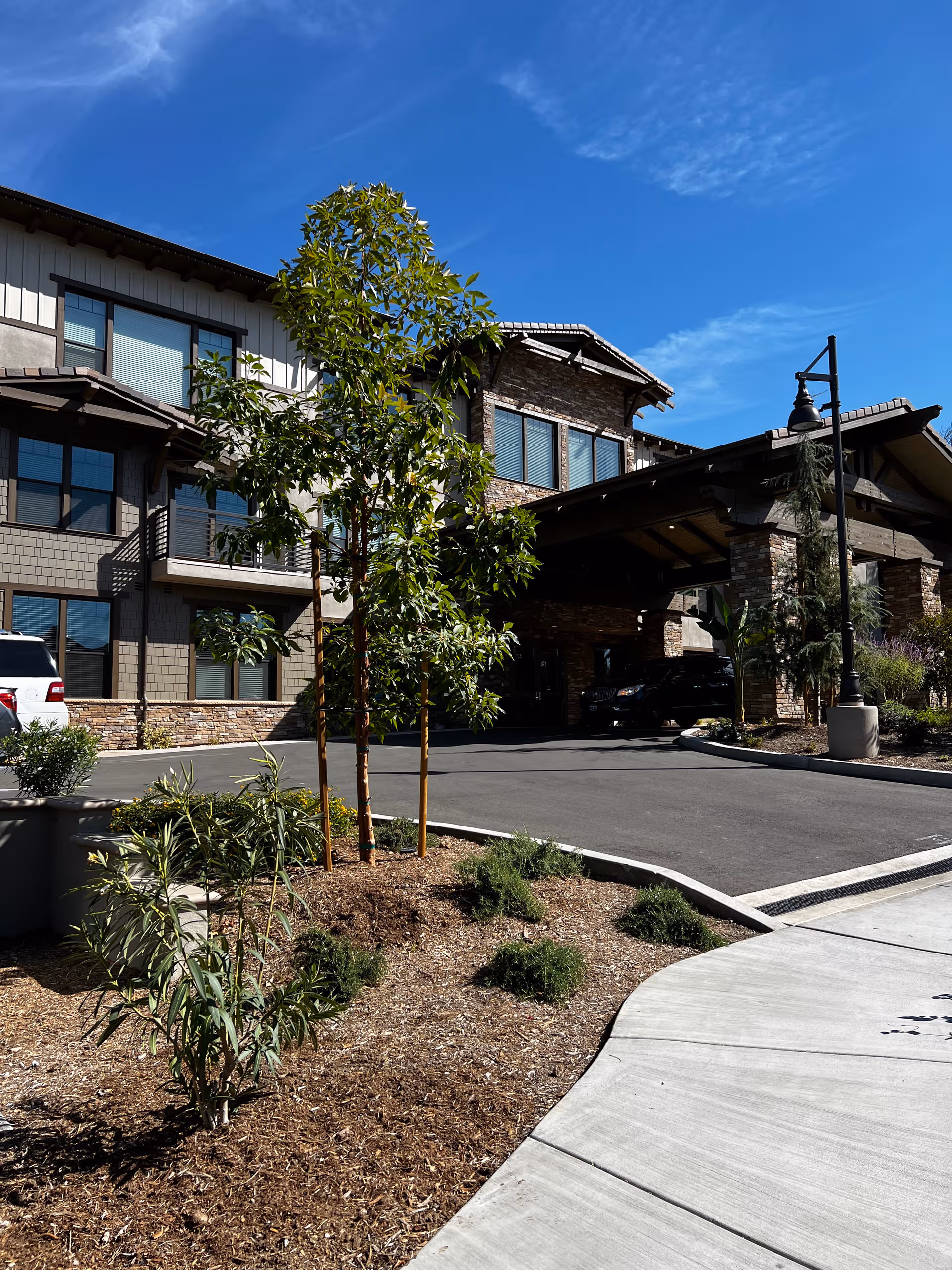 Exterior view of Park View Place Senior Living with driveway, trees, and covered entrance.
