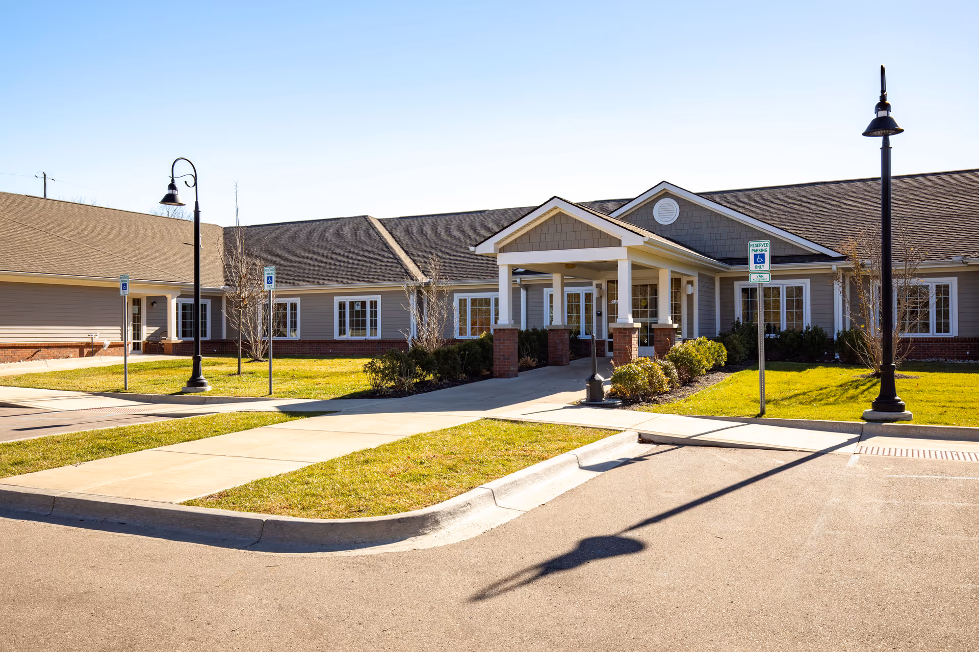 Exterior view of Mission Point Nursing and Rehab Center of Holly entrance with landscaping.