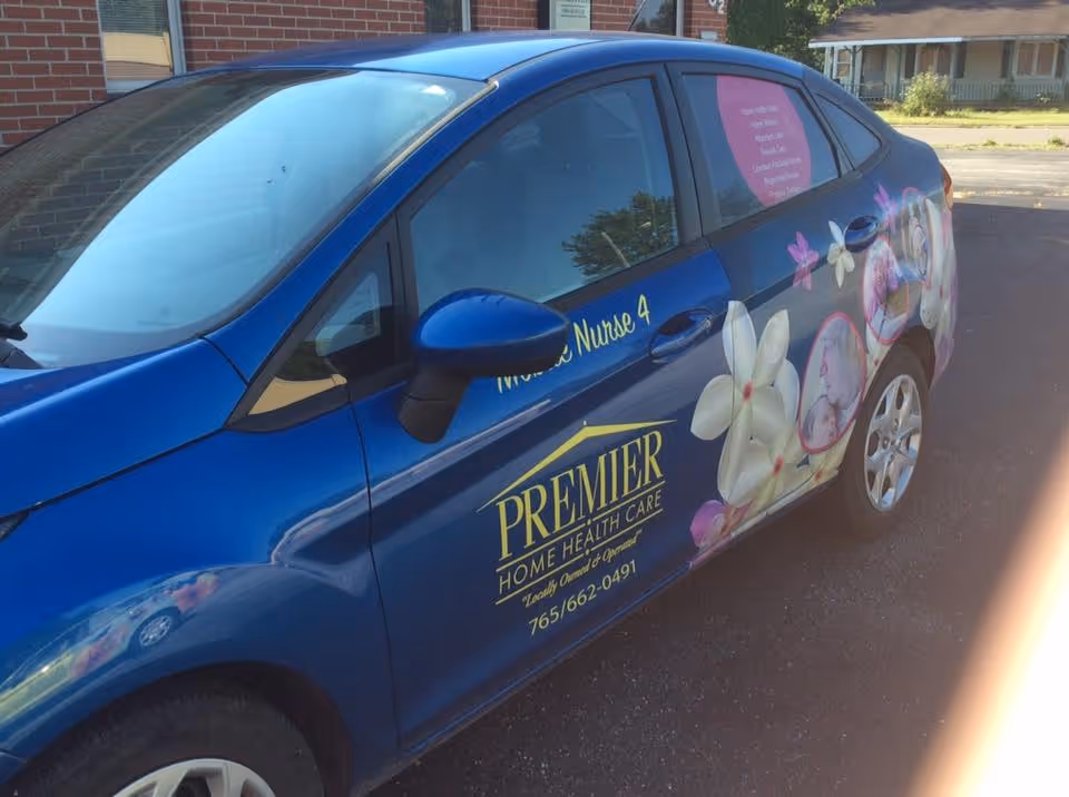 Blue van with Premier Home Health Care branding parked outside.