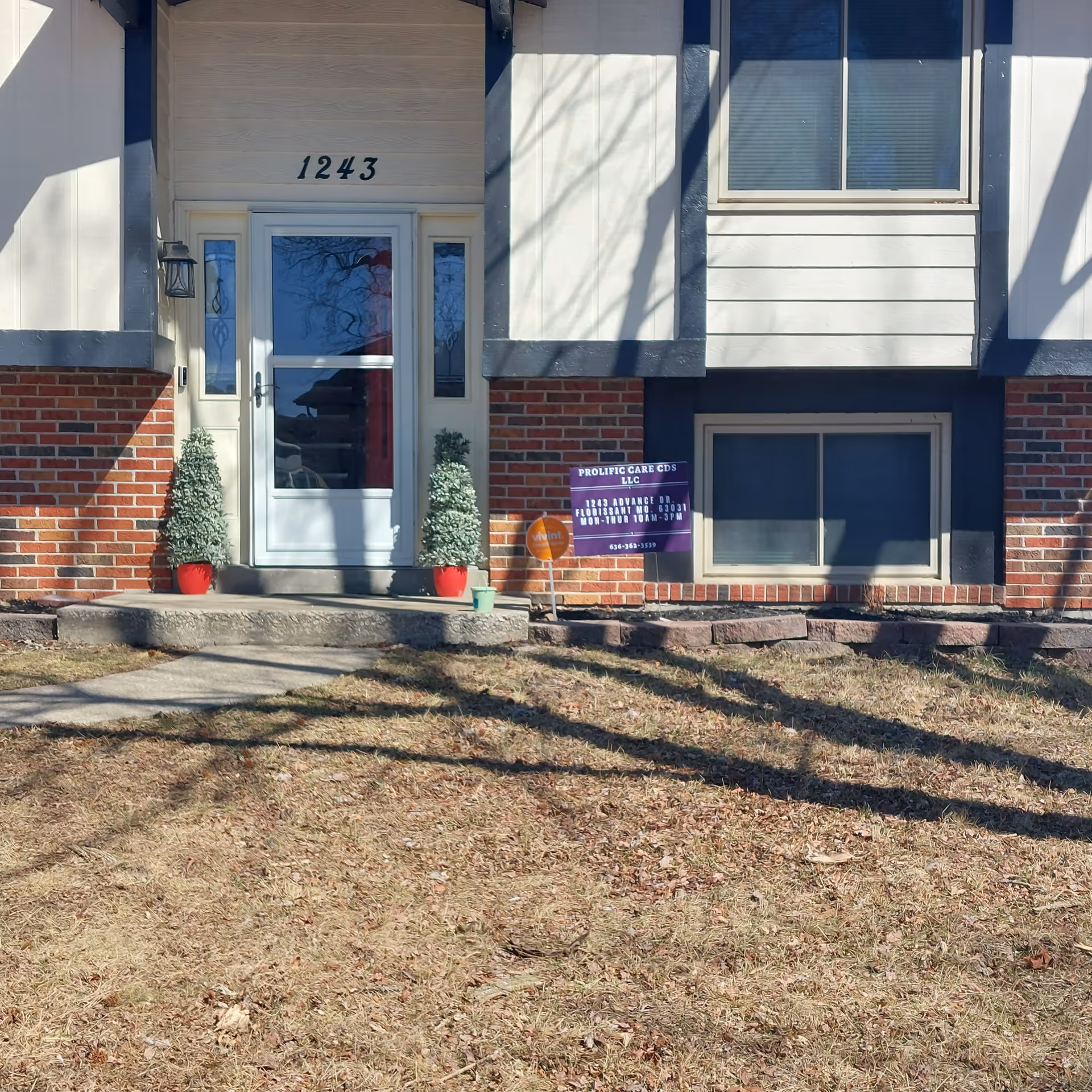 Front exterior of a senior living facility with a glass door and sign.
