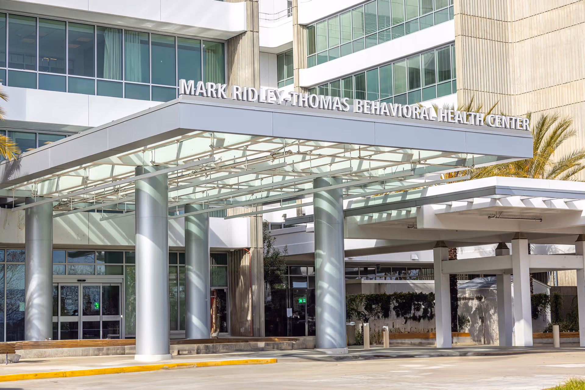 Modern medical center exterior with glass facade and a covered entrance canopy