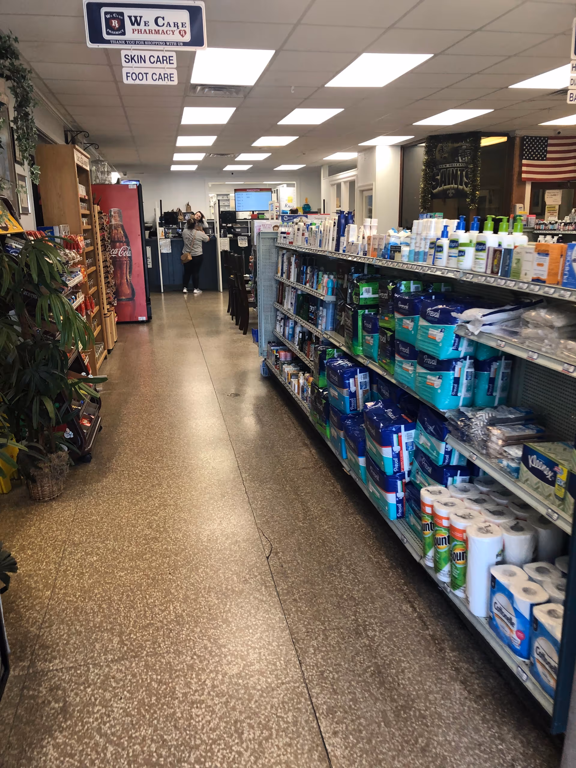 Long indoor aisle at Patio Drugs in a senior living facility with product shelves.