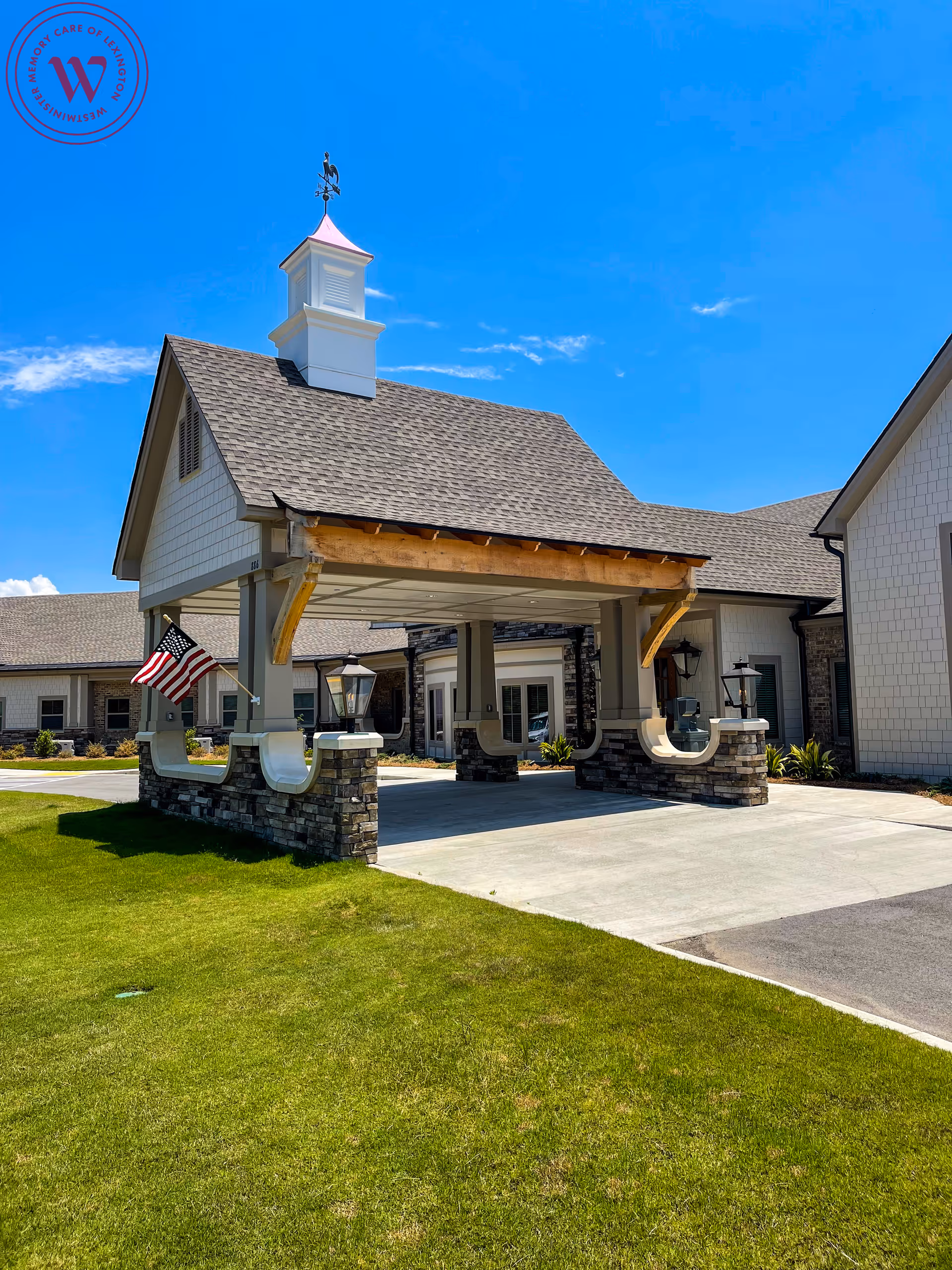 Exterior view of Westminster Memory Care facility with a porte-cochere entrance and manicured lawn.