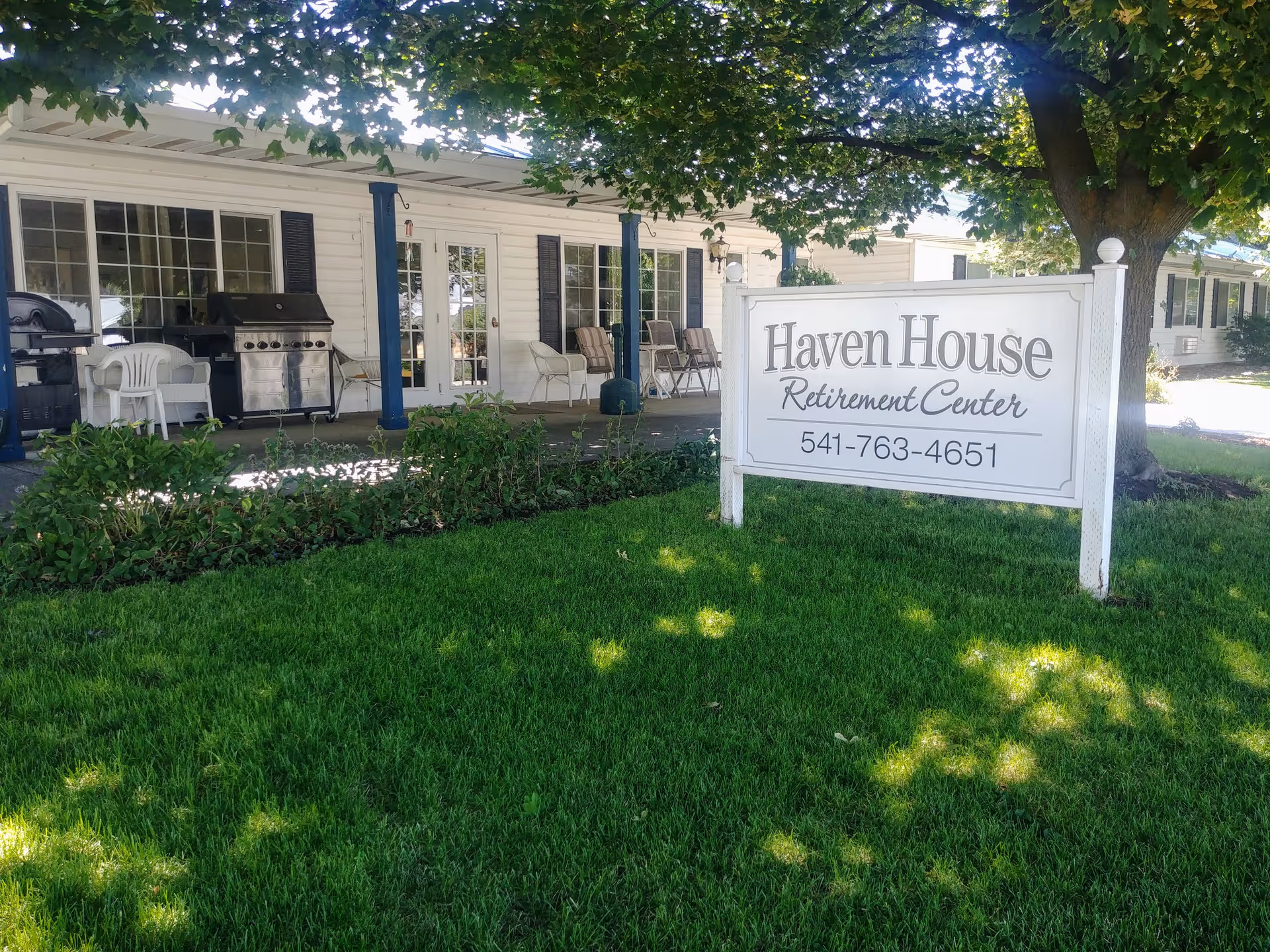 Front of Haven House Retirement Center with a large sign, porch seating, and green lawn.