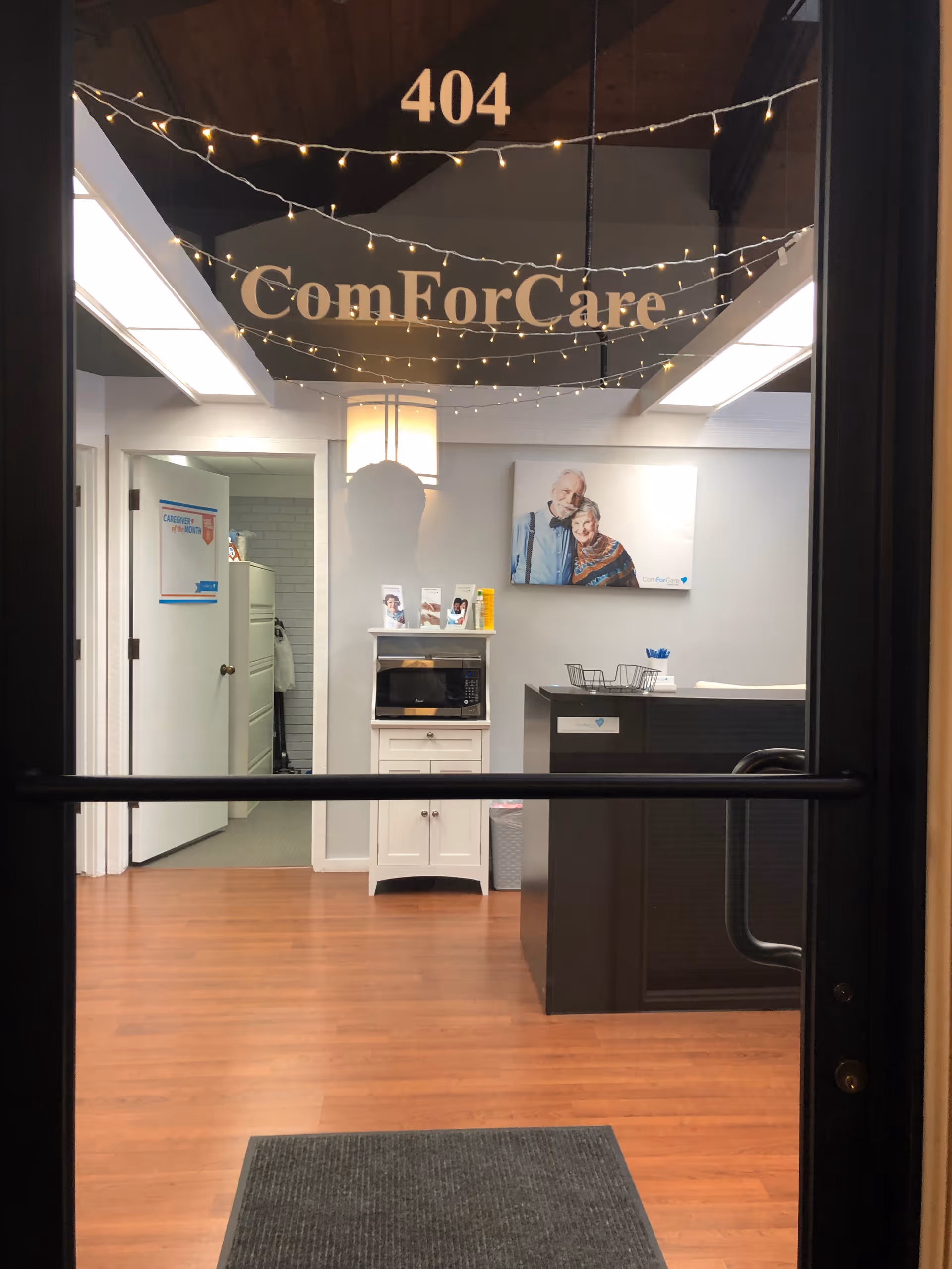 Interior reception area viewed through glass door with ComForCare signage.
