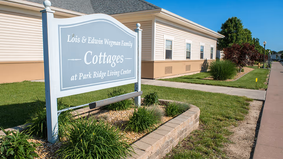 Exterior of Park Ridge Living Center with a sign for Lois & Edwin Wegman Family Cottages.
