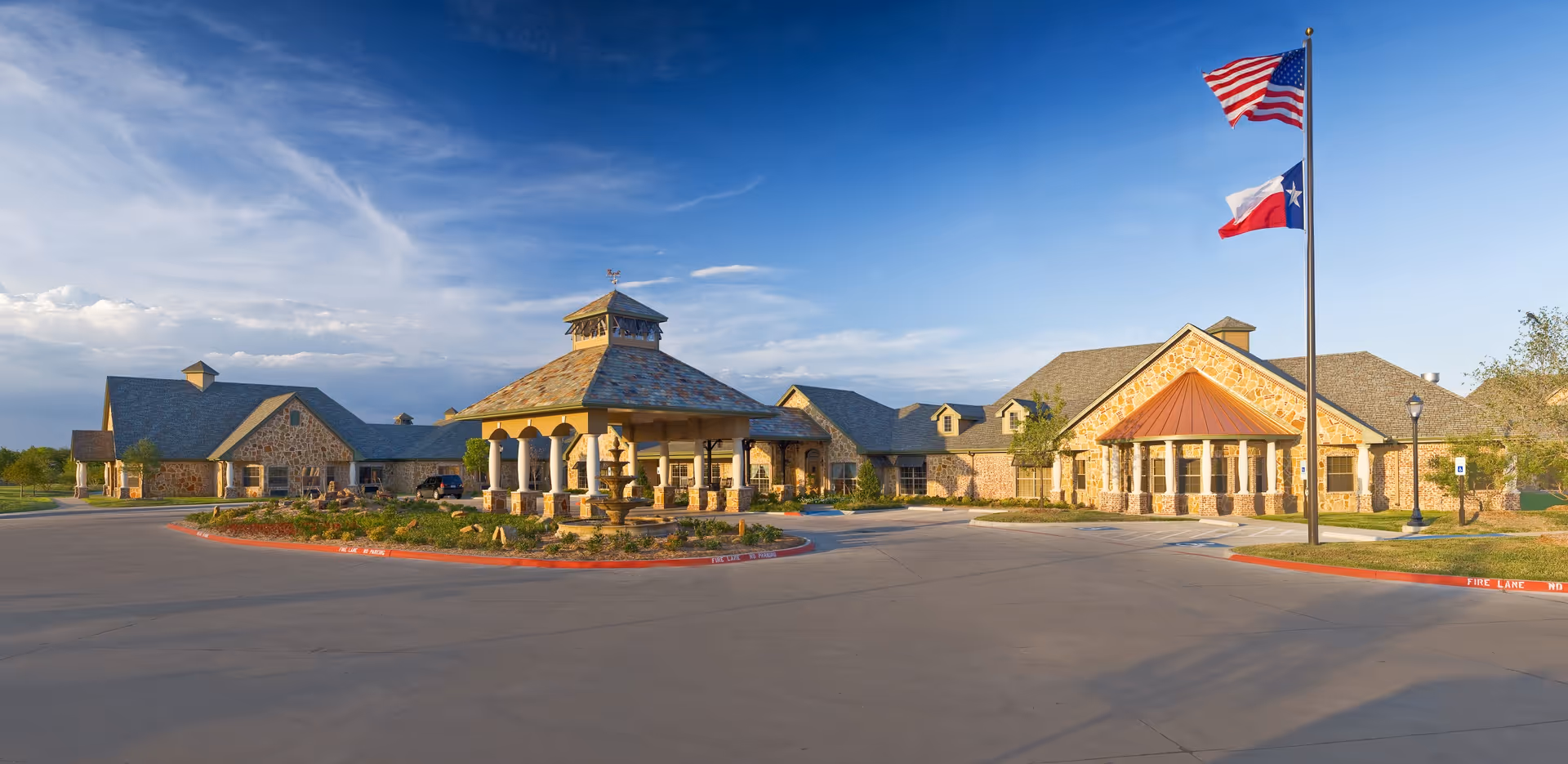 Exterior view of Garnet Hill Rehabilitation and Skilled Care facility with flagpoles and a circular driveway