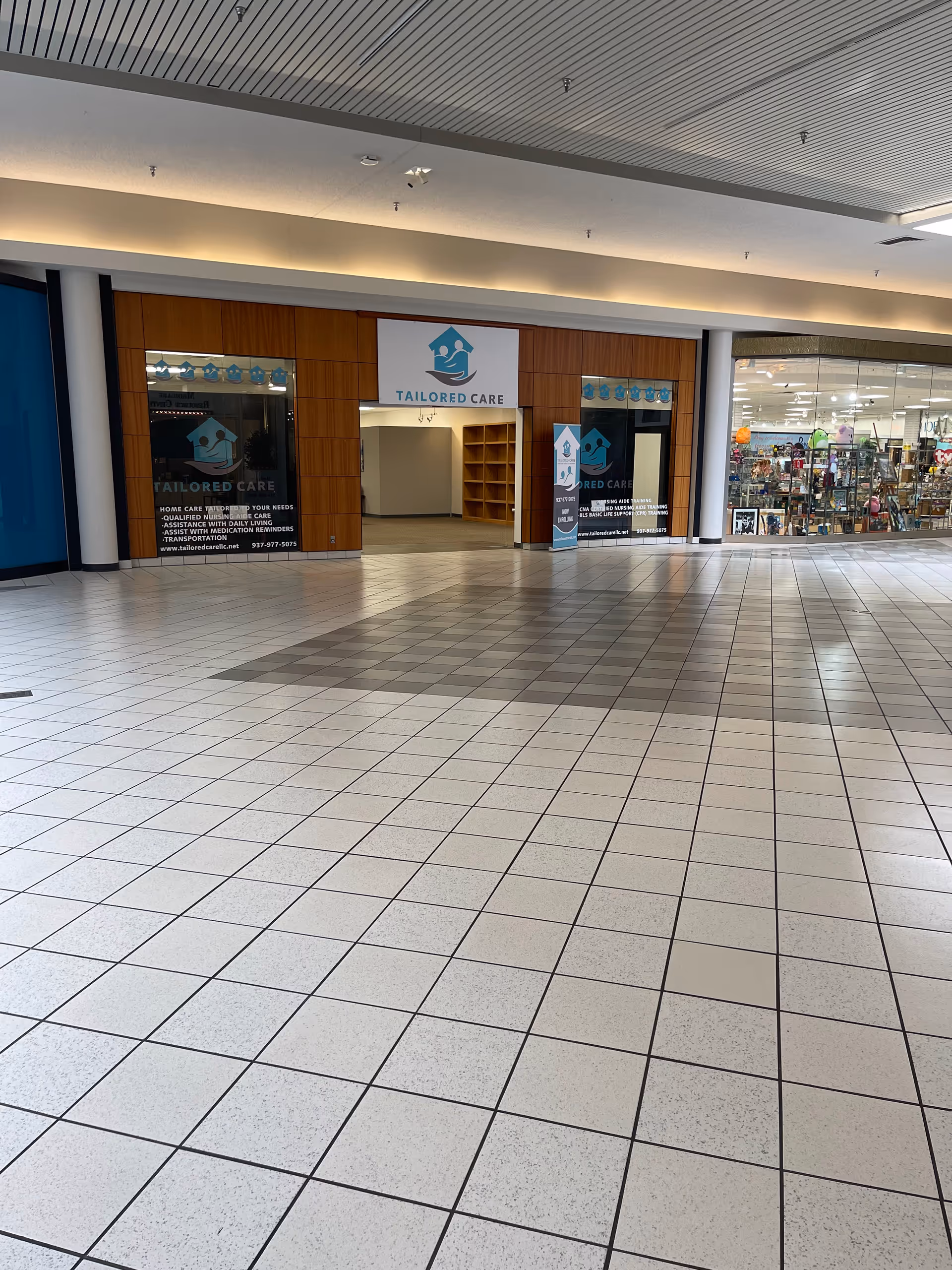 Mall corridor storefront for Tailored Care LLC with signage and glass displays.