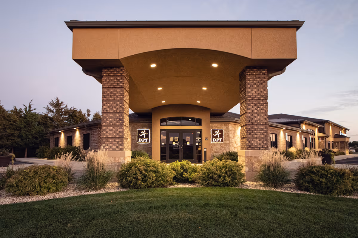 Front entrance of a modern senior care facility with brick pillars and porte-cochère.