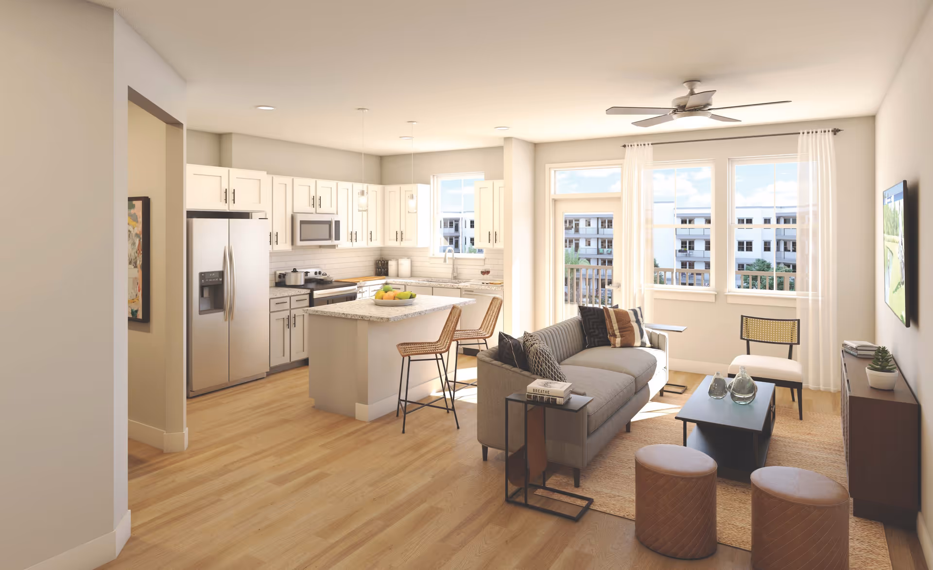 Bright open-plan living room and kitchen with a sofa, coffee table, island with bar stools, and large windows.