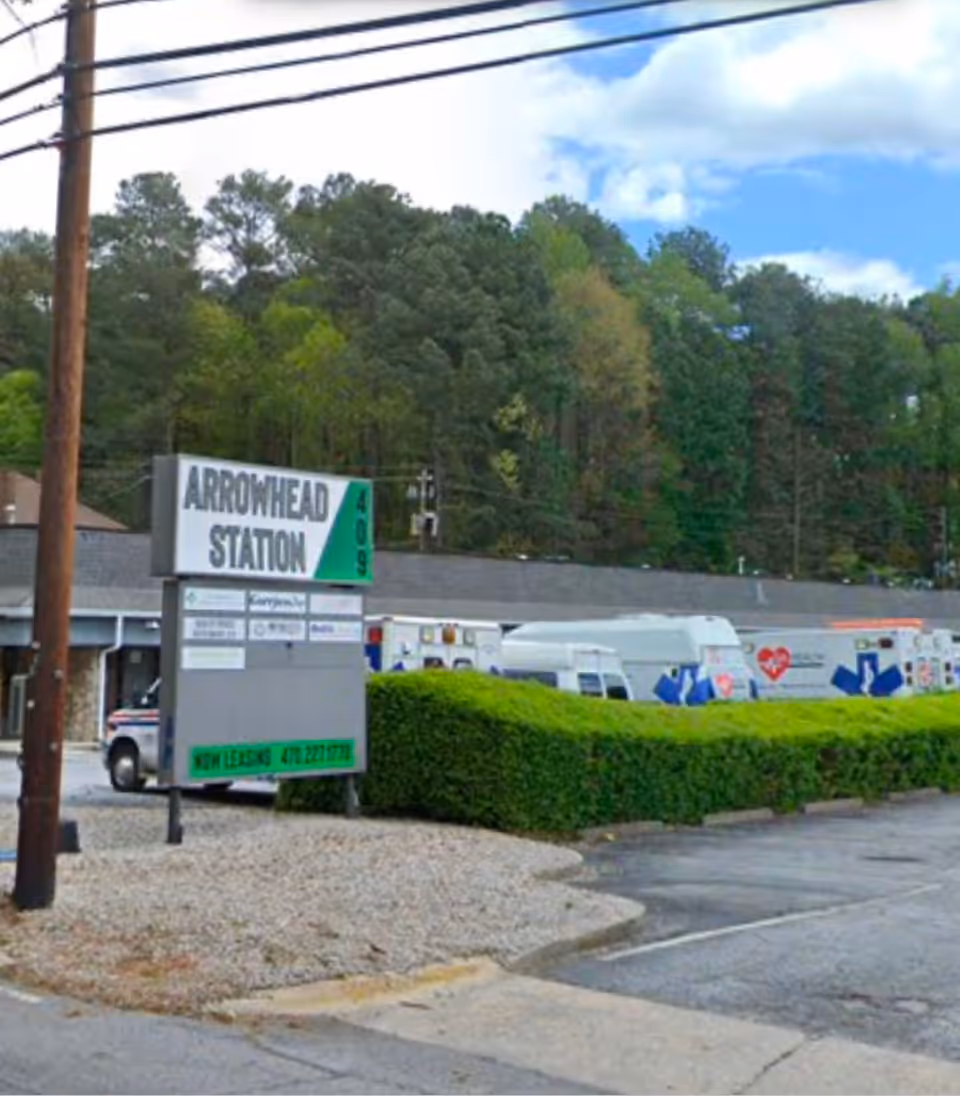 Exterior view of Arrowhead Station with ambulances and green shrubbery.