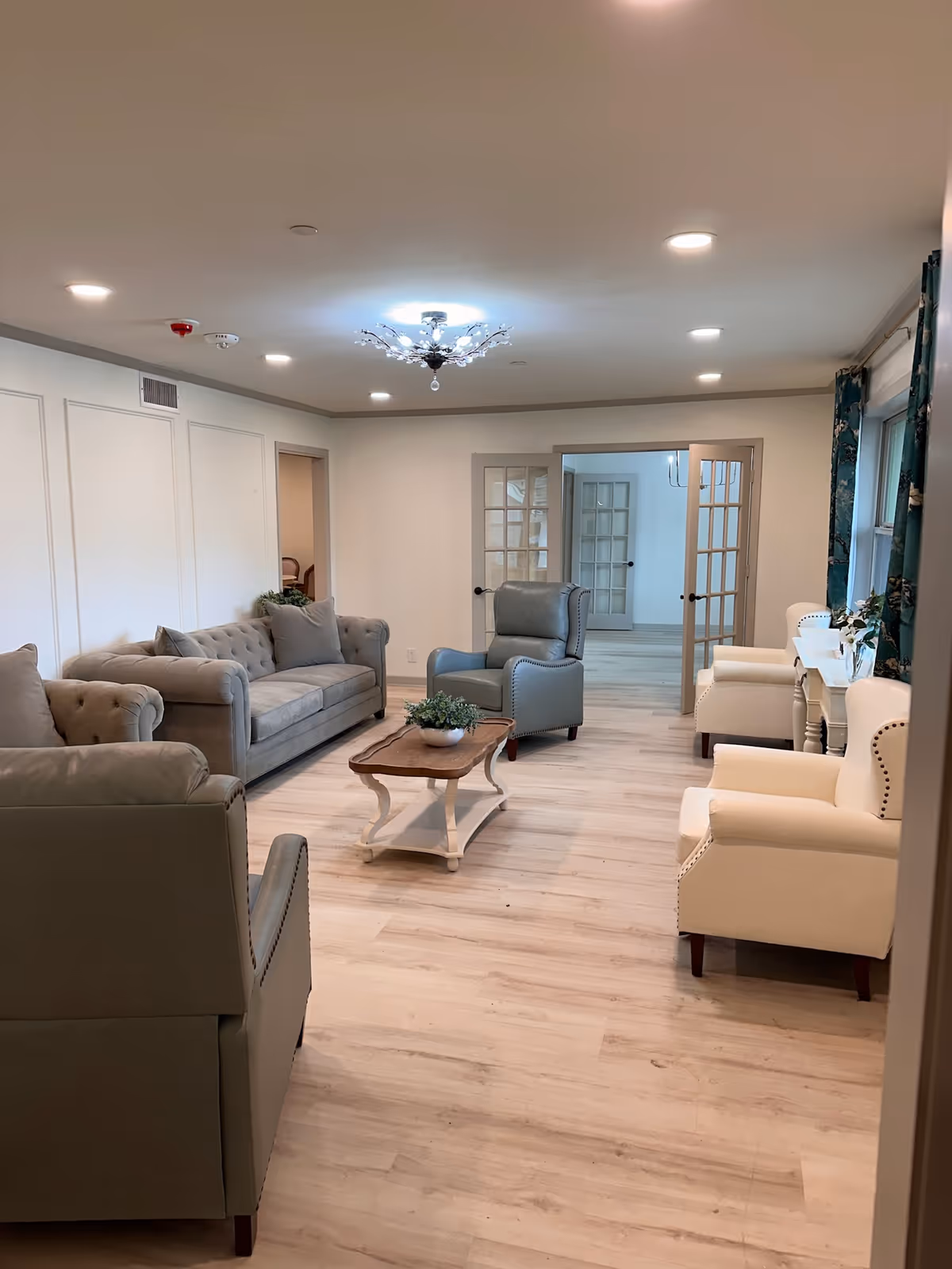 A spacious lounge with couches, chairs, and a coffee table in a bright, modern living room.