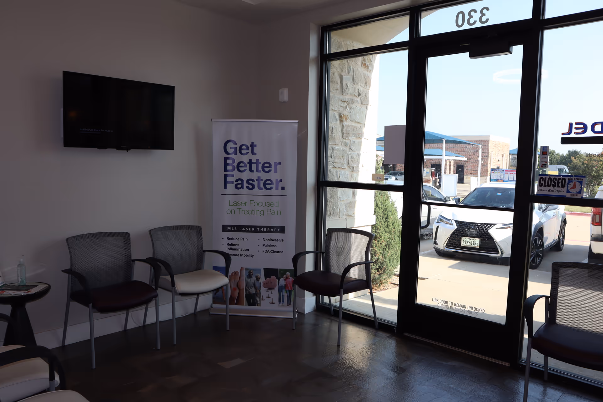 Lobby of Alpha Physical Therapy, LLC showing chairs, a banner, and a wall-mounted TV.
