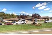 Exterior view of Rolling Hills Healthcare and Rehabilitation Center with parking and flagpole.