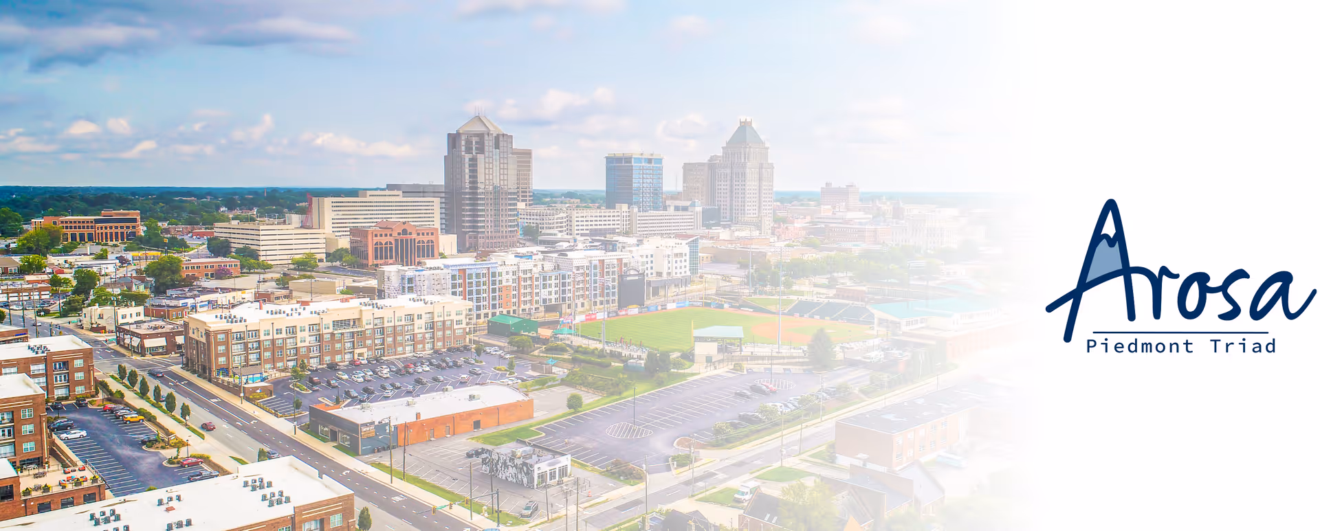 Aerial view of the Arosa Piedmont Triad campus with surrounding city skyline.