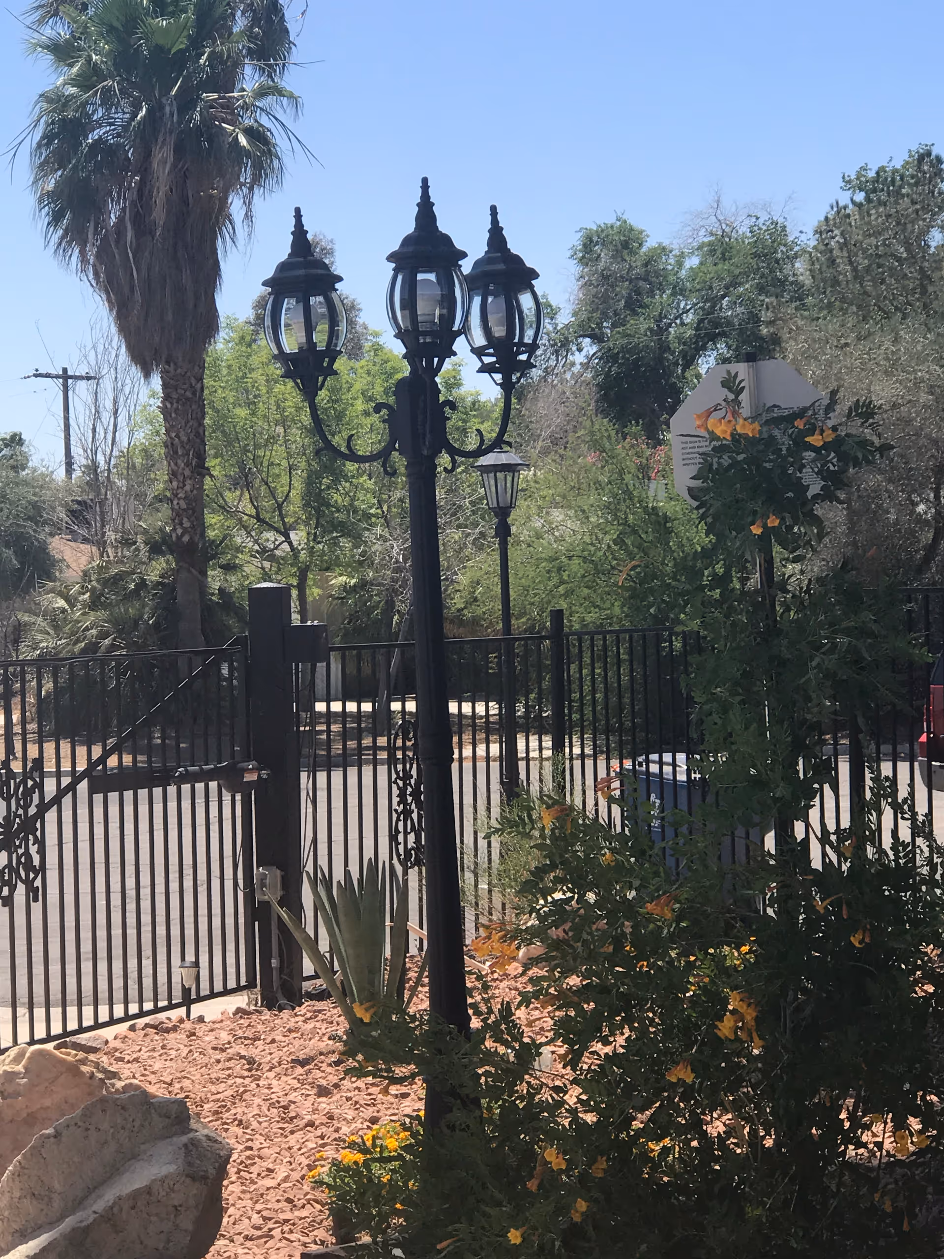 Gated exterior with ornate lampposts and desert landscaping.
