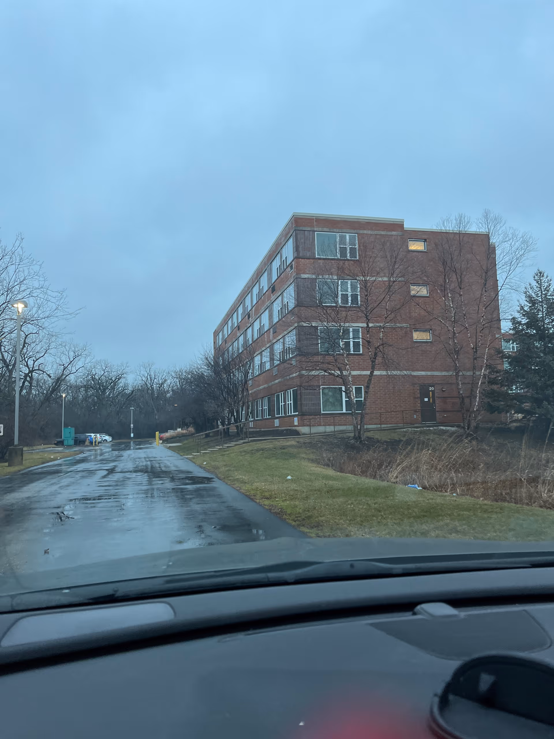 Exterior view of Cantata Adult Life Services building along a damp road, with leafless trees.