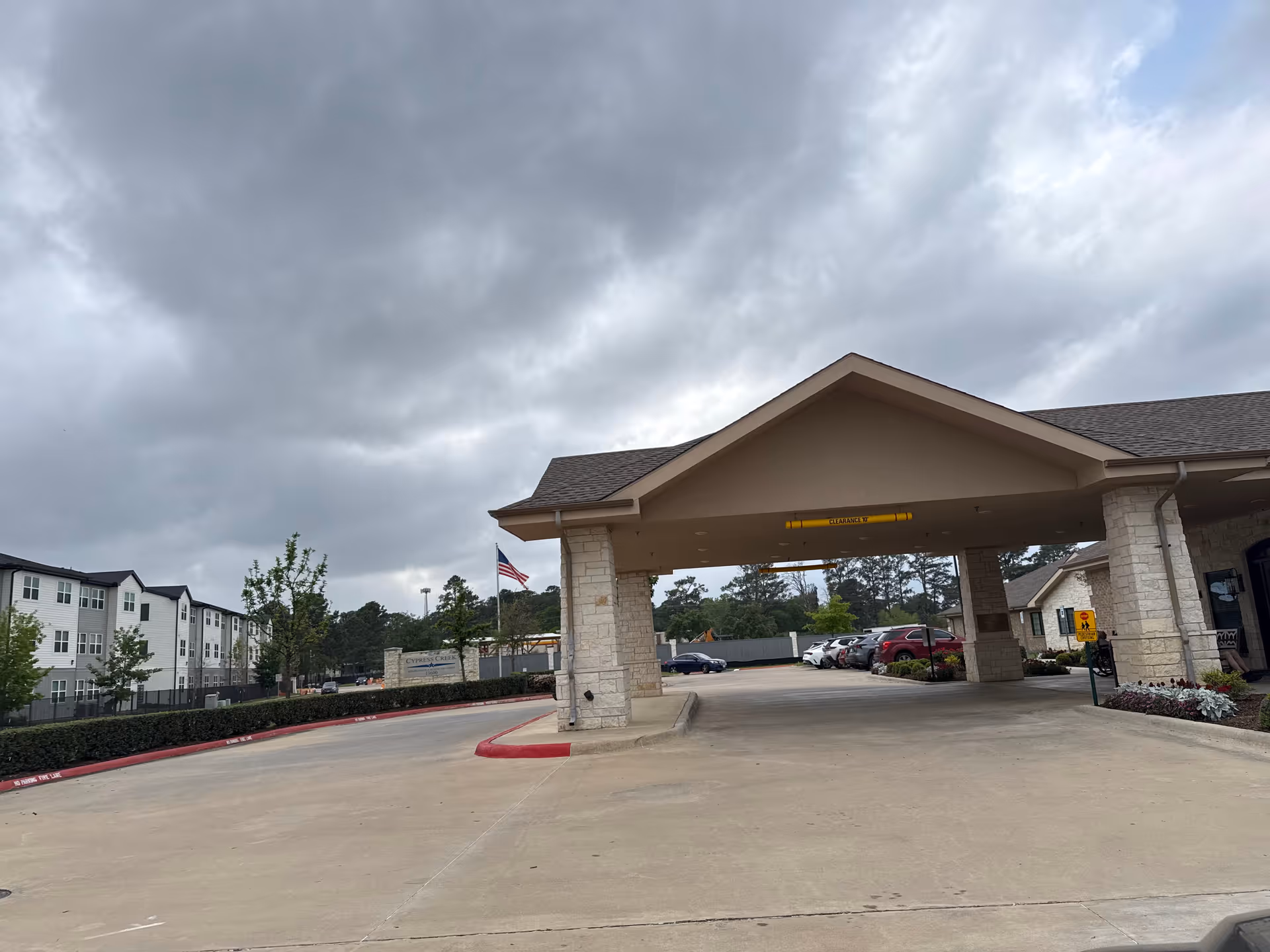 Exterior view of Cypress Creek Rehabilitation and Healthcare Center entrance under cloudy sky.