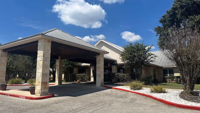 Front entrance of Meridian Care building with a covered drive-through entry and stone columns