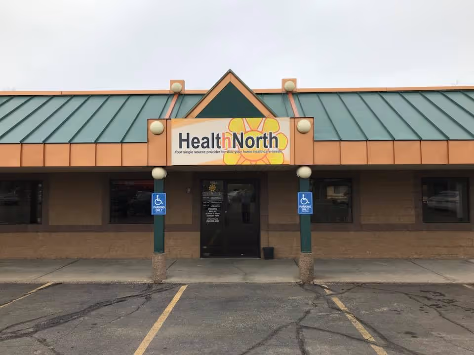 Front of HealthNorth facility with sign, entrance, and handicap parking spaces.