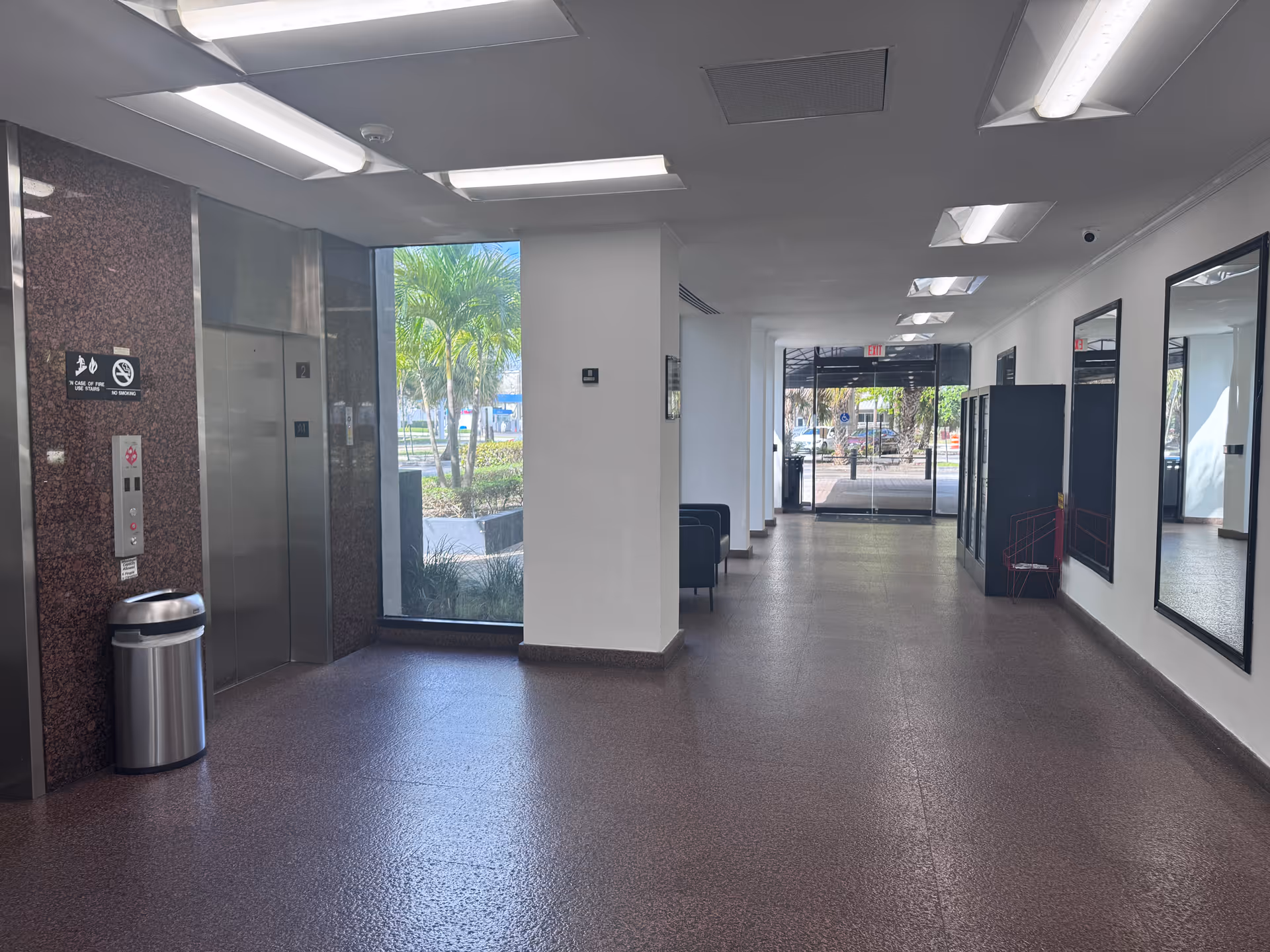 Bright interior corridor of VidaWell Care with elevators, seating, and large windows.