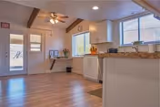 Bright open interior with a kitchen island, cabinets, and large windows.