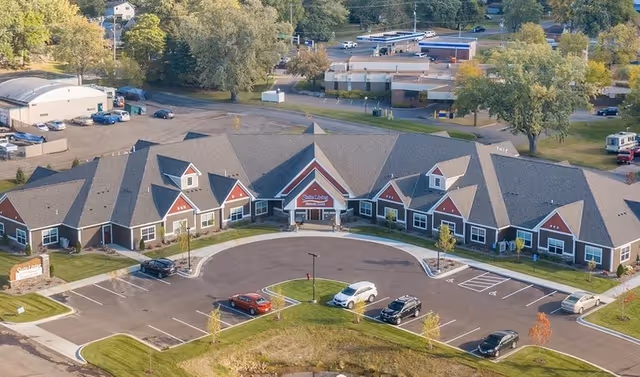 Aerial view of Suite Living Senior Care of West St. Paul exterior building with parking.