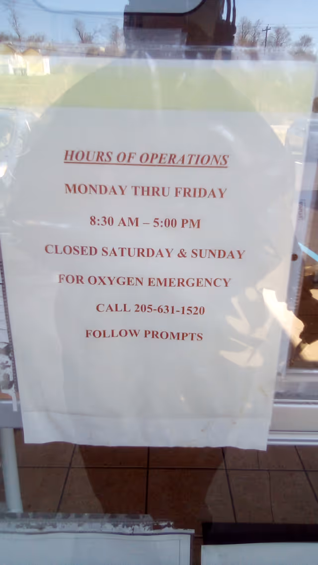 Sign on glass door lists hours of operation for Jernigan Healthcare.