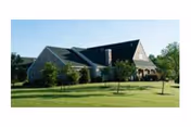 Exterior view of Meadowood Senior Living building with green lawn and trees.