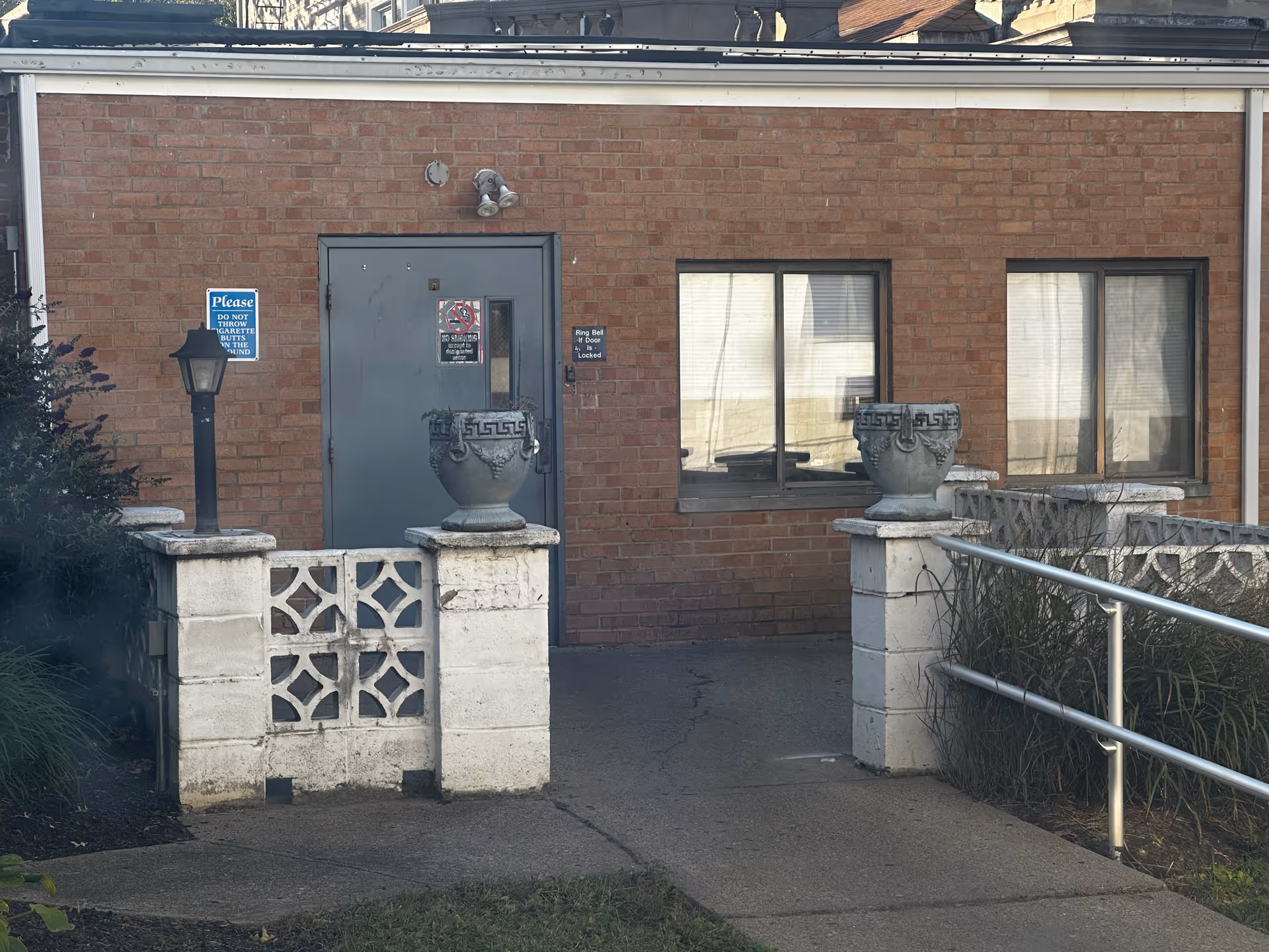 Brick exterior of Garden Park Health Care Center with a gray entrance door and railings.
