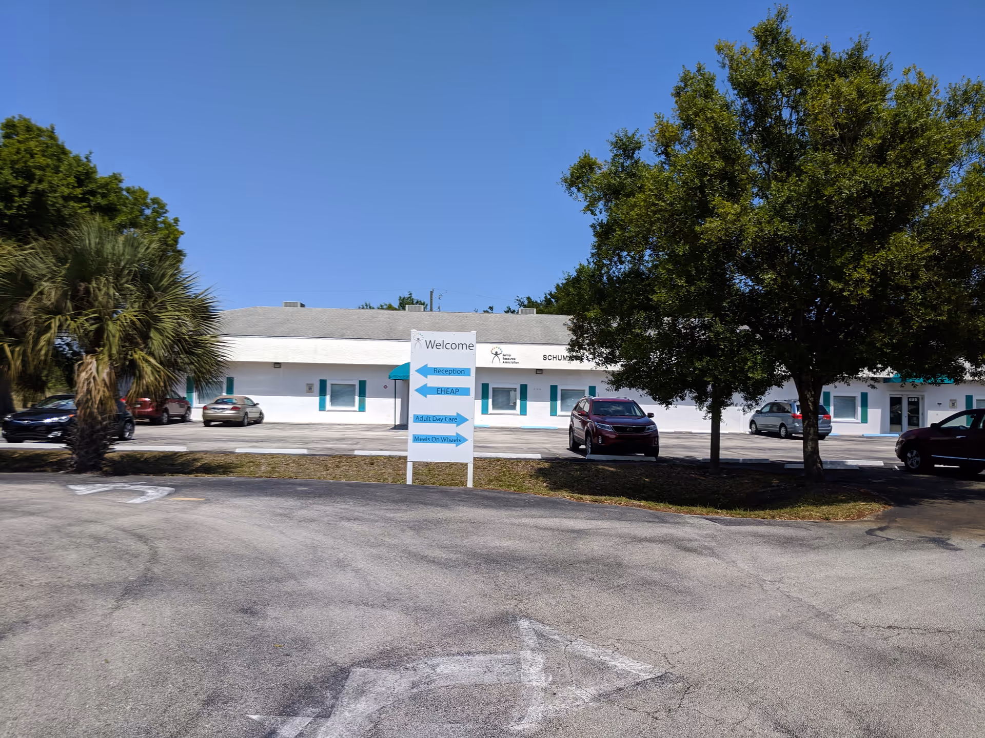 Exterior view of Senior Resource Association building with a welcome sign and trees.
