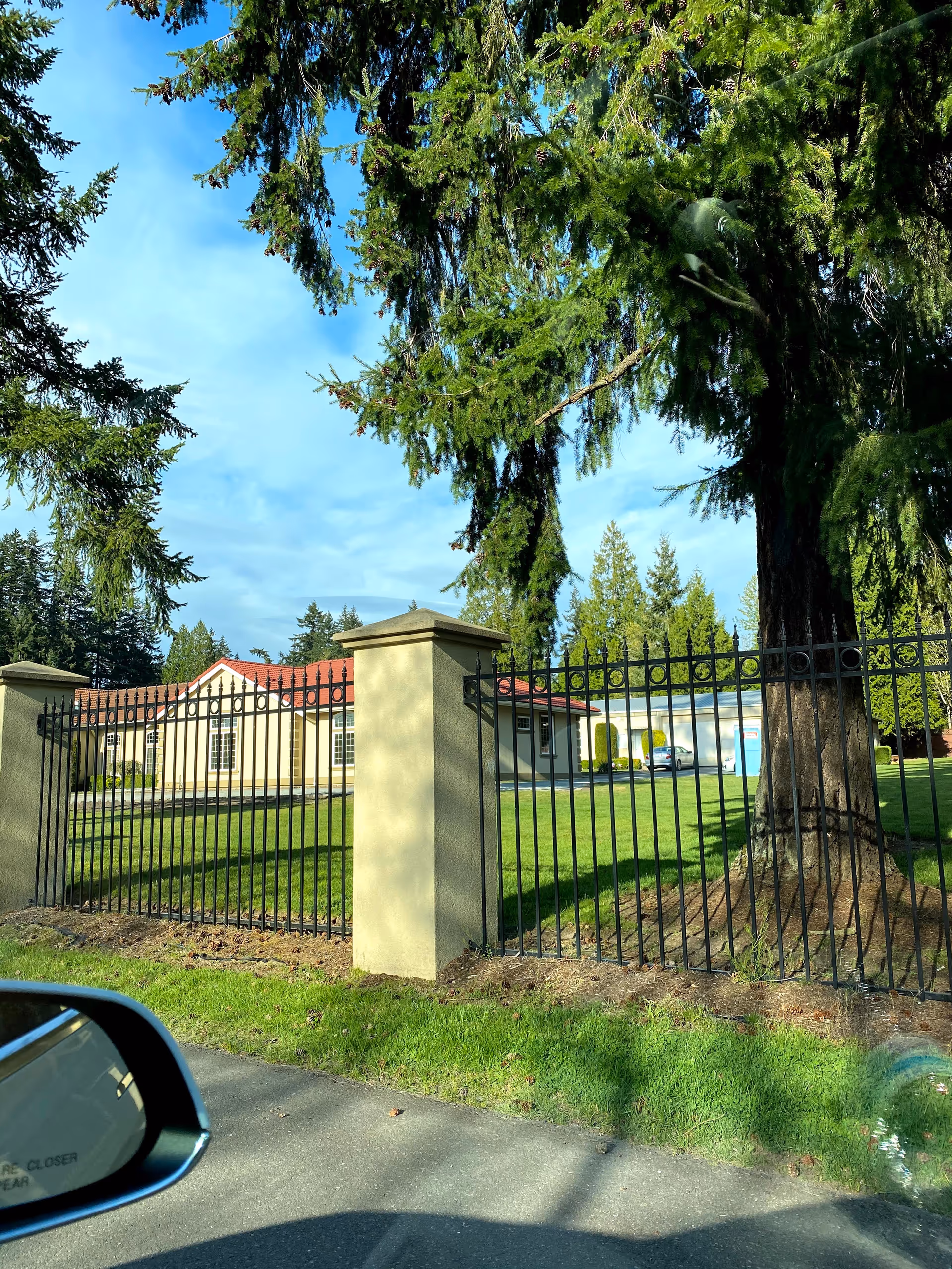 Exterior view of Loving Adult Family Home with fence, gate, and manicured lawn.