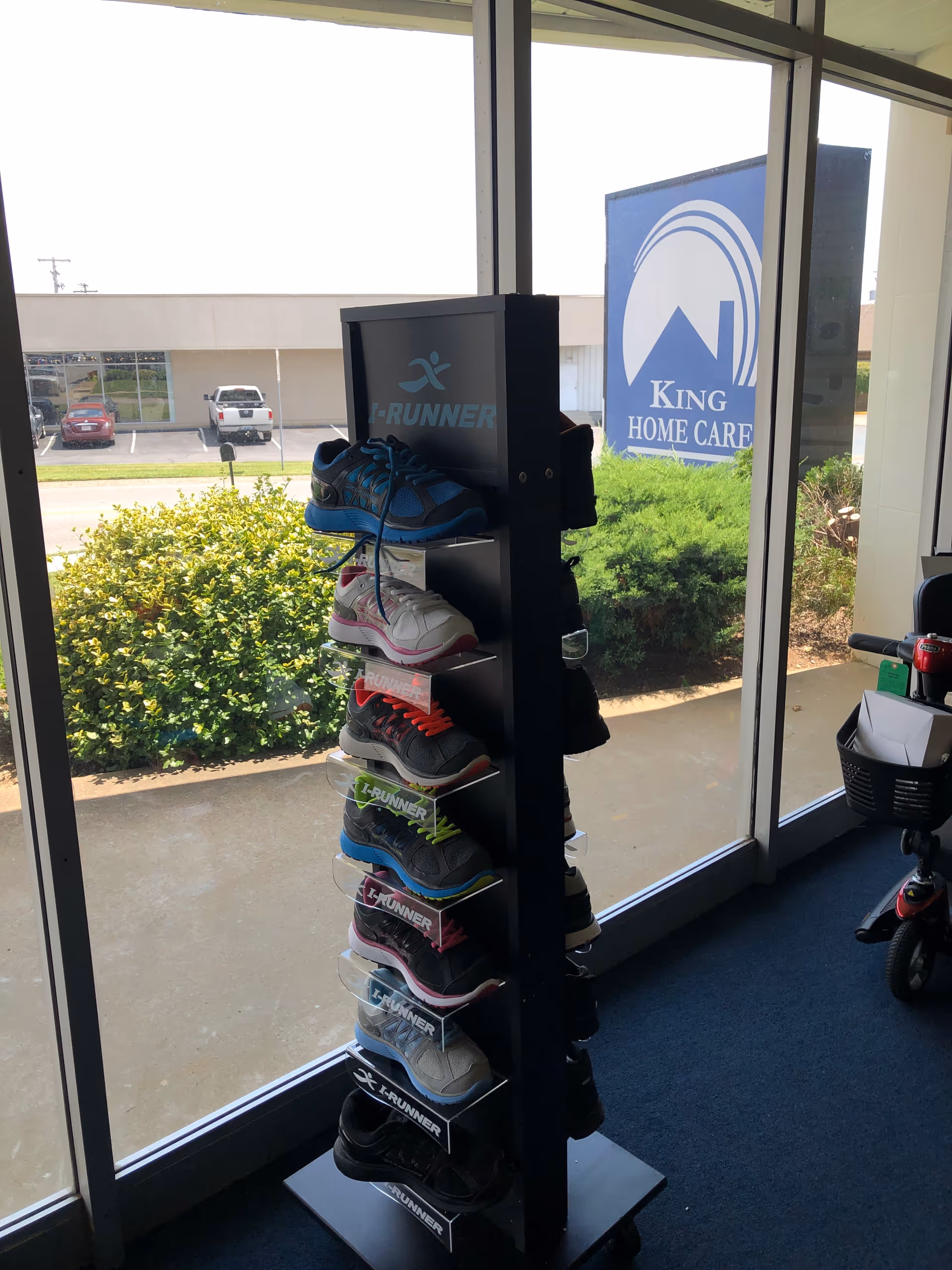 Tall shoe display rack with colorful sneakers inside a King Home Care facility