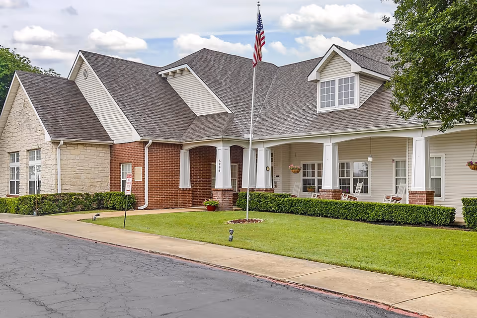 Exterior view of a Brookdale senior living building with a flagpole and manicured lawn.