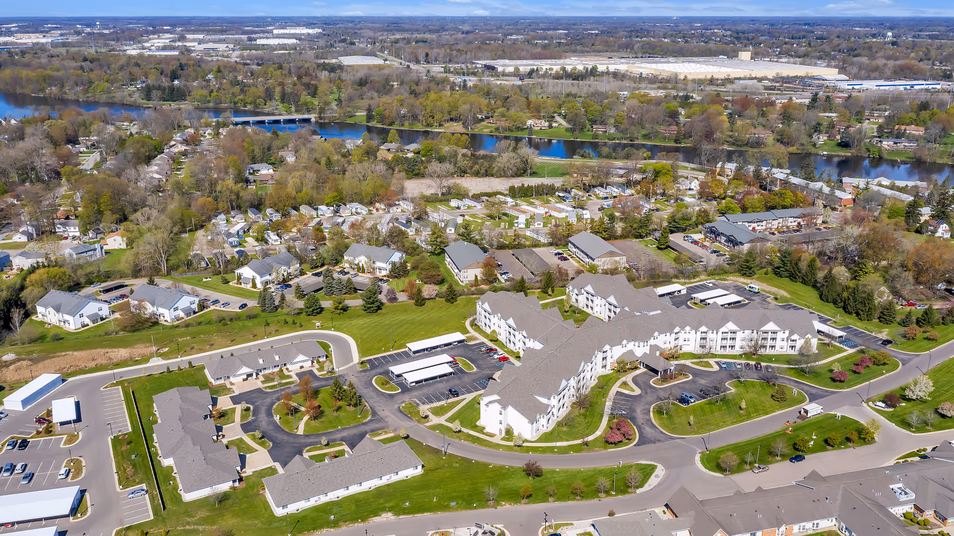Aerial view of Grandhaven Manor II campus with multiple buildings, roads, and a nearby river.