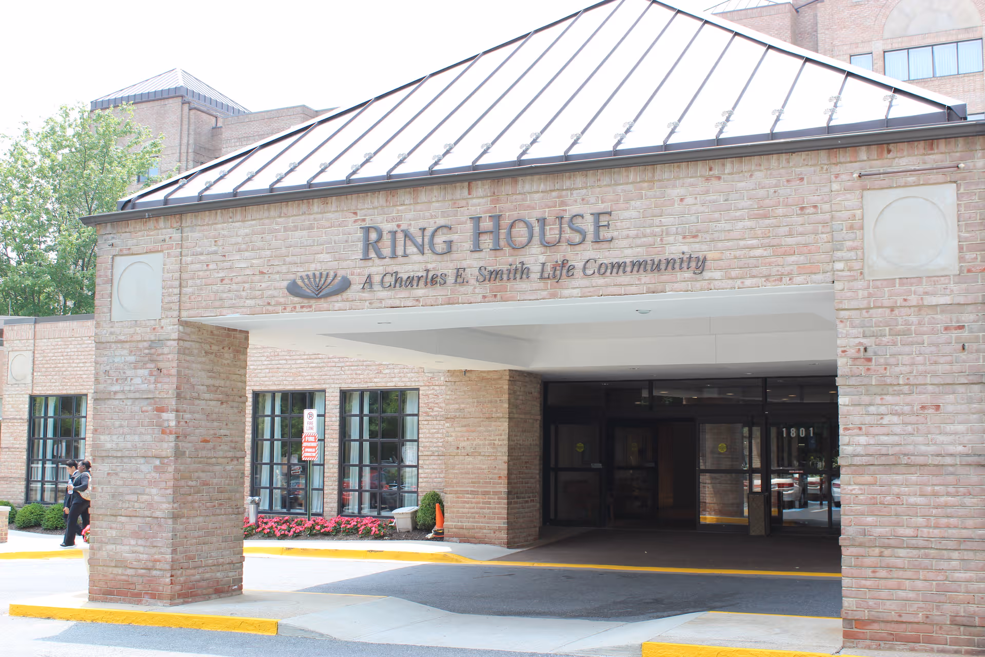 Brick building entrance for Ring House with canopy and glass doors.