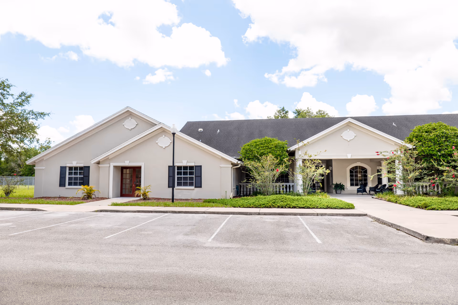 Front exterior view of a single-story senior living facility with a parking lot.